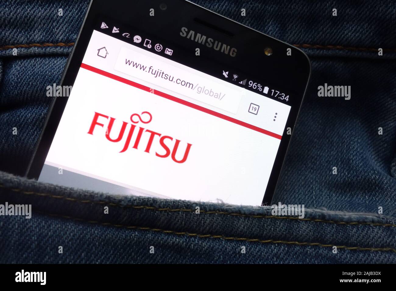 Fujitsu website displayed on Samsung smartphone hidden in jeans pocket Stock Photo
