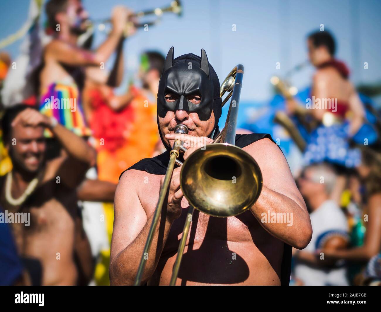 Masked musician playing the trombone during Carnaval street parade in Rio de Janeiro, Brazil. Stock Photo