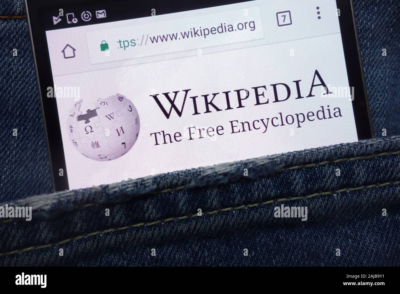 Wikipedia website displayed on smartphone hidden in jeans pocket Stock Photo