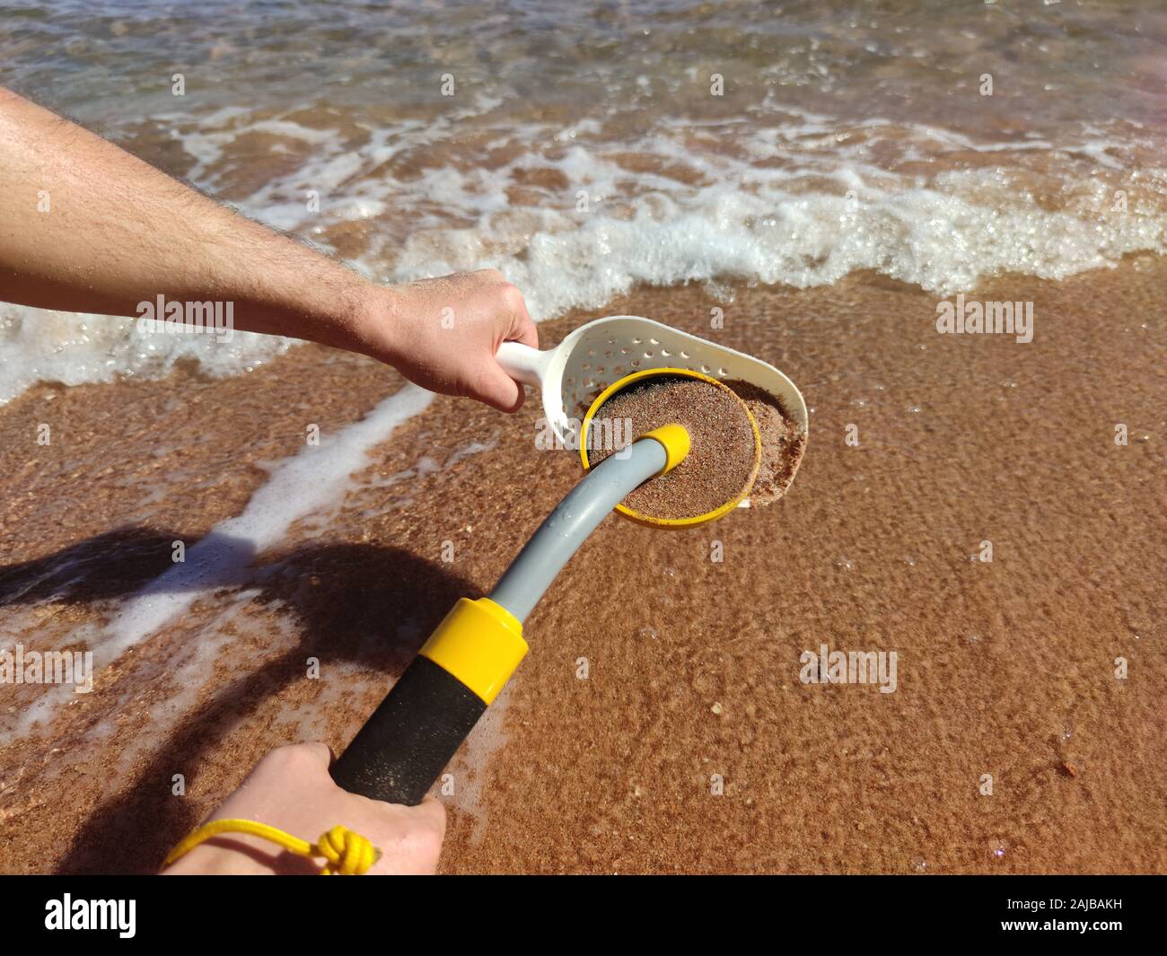 The photo of an underwater metal detector and a shovel on the sand.Treasure searching and tourist adventure background. Stock Photo