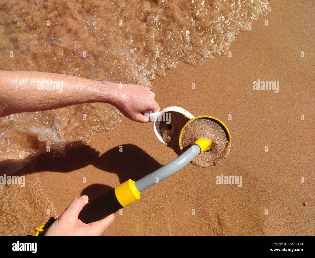 The photo of an underwater metal detector and a shovel on the sand.Treasure searching and tourist adventure background. Stock Photo