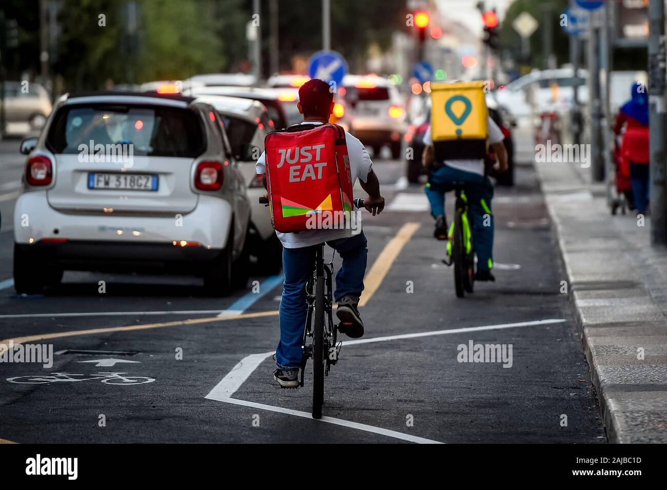 Turin Italy 30 July 2019 A Just Eat and a Glovo couriers ride during his work. Just Eat and Glovo are a online food delivery apps as Uber Eats and Foodora