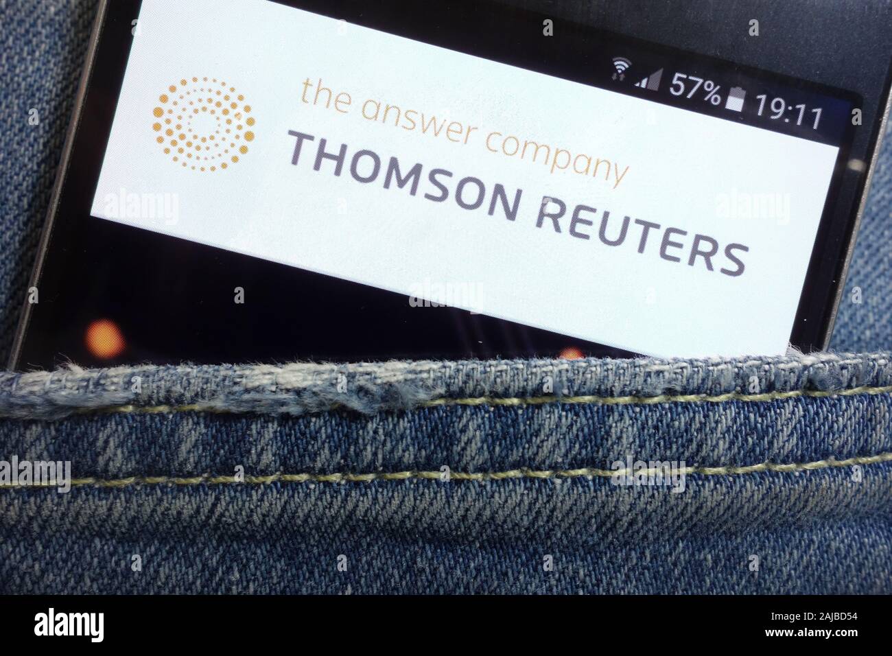 Thomson Reuters website displayed on smartphone hidden in jeans pocket Stock Photo