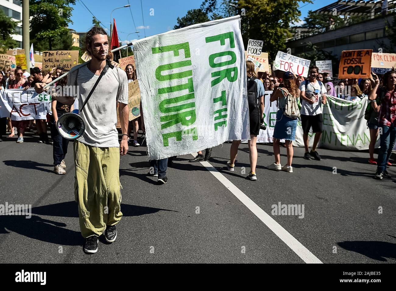 Lausanne, Switzerland - 09 August, 2019: A climate activist holds a flag reading 'For the future' during a Fridays For Future strike for climate protection that is part of 'SMILE for Future' event. More than 450 young climate activists from different European countries gathered to attend the summit 'SMILE for Future', that stands for Summer Meeting in Lausanne Europe. The aim of the summit is to reinforce the links between the participants of the European Youth Climate Strike movement and to define the future of the mobilisation against climate change. Credit: Nicolò Campo/Alamy Live News Stock Photo