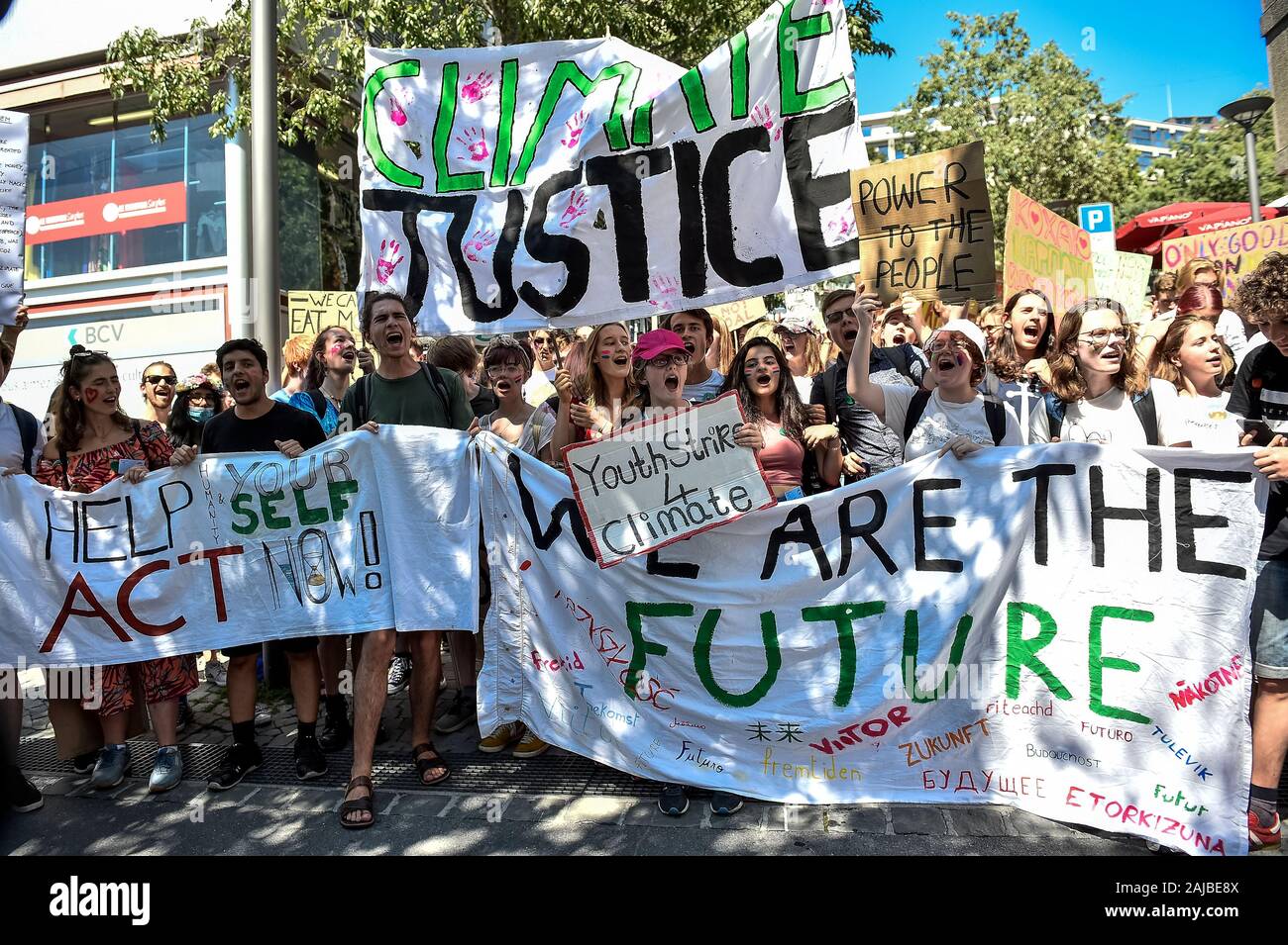 Lausanne, Switzerland - 09 August, 2019: Climate activists hold banners  reading 'Help yourself act now', Climate justice', 'We are the future'  during a Fridays For Future strike for climate protection that is
