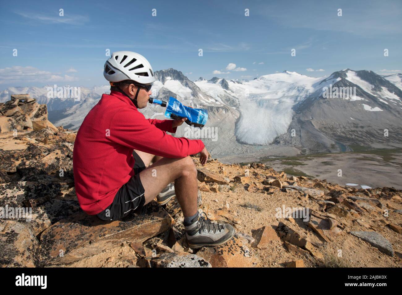 hiker drinking filtered water on mountain summit. Stock Photo