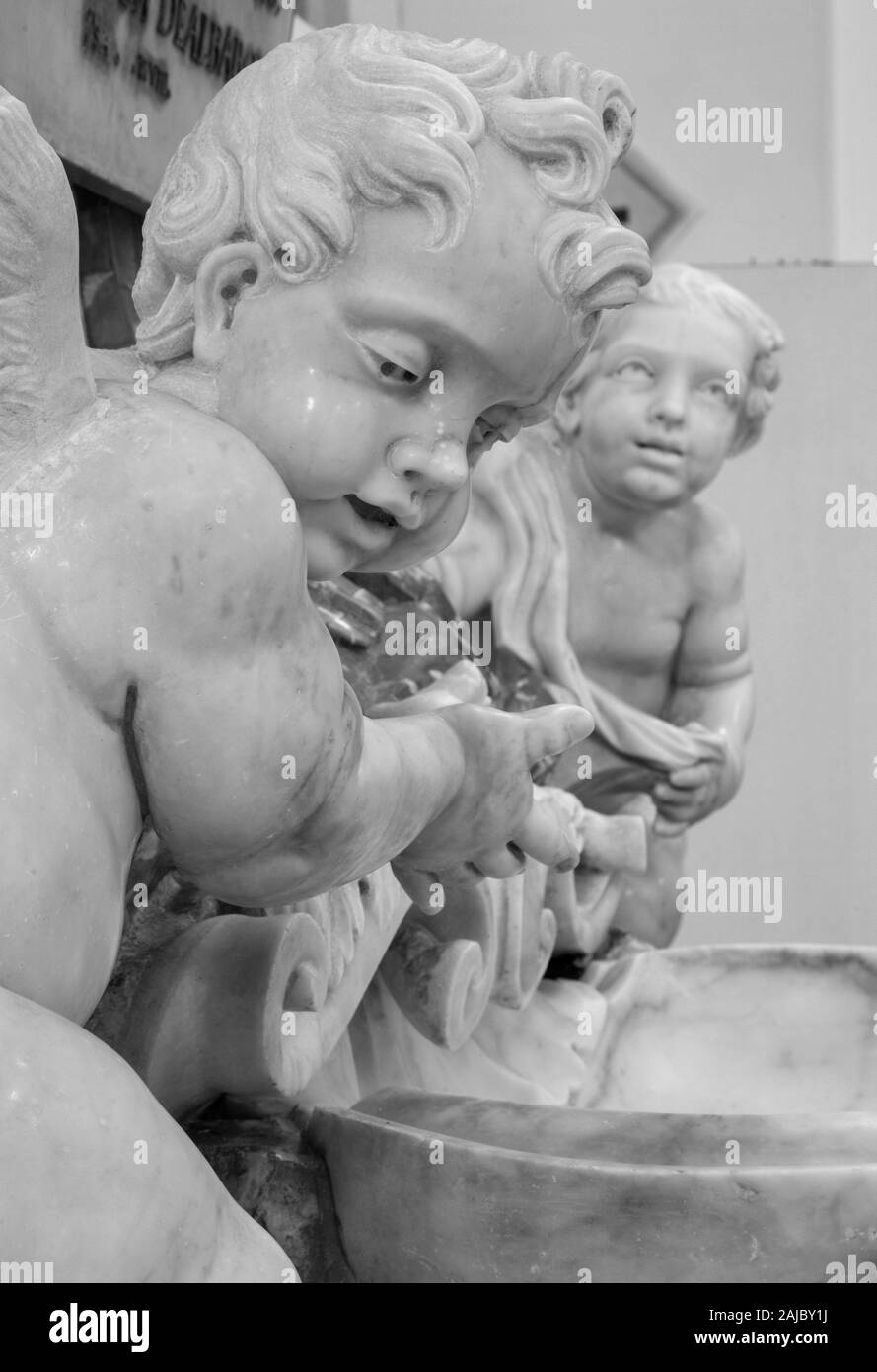 CATANIA, ITALY - APRIL 7, 2018: The detail of angels and baroque marble stoup in Chiesa di San Nicolo. Stock Photo