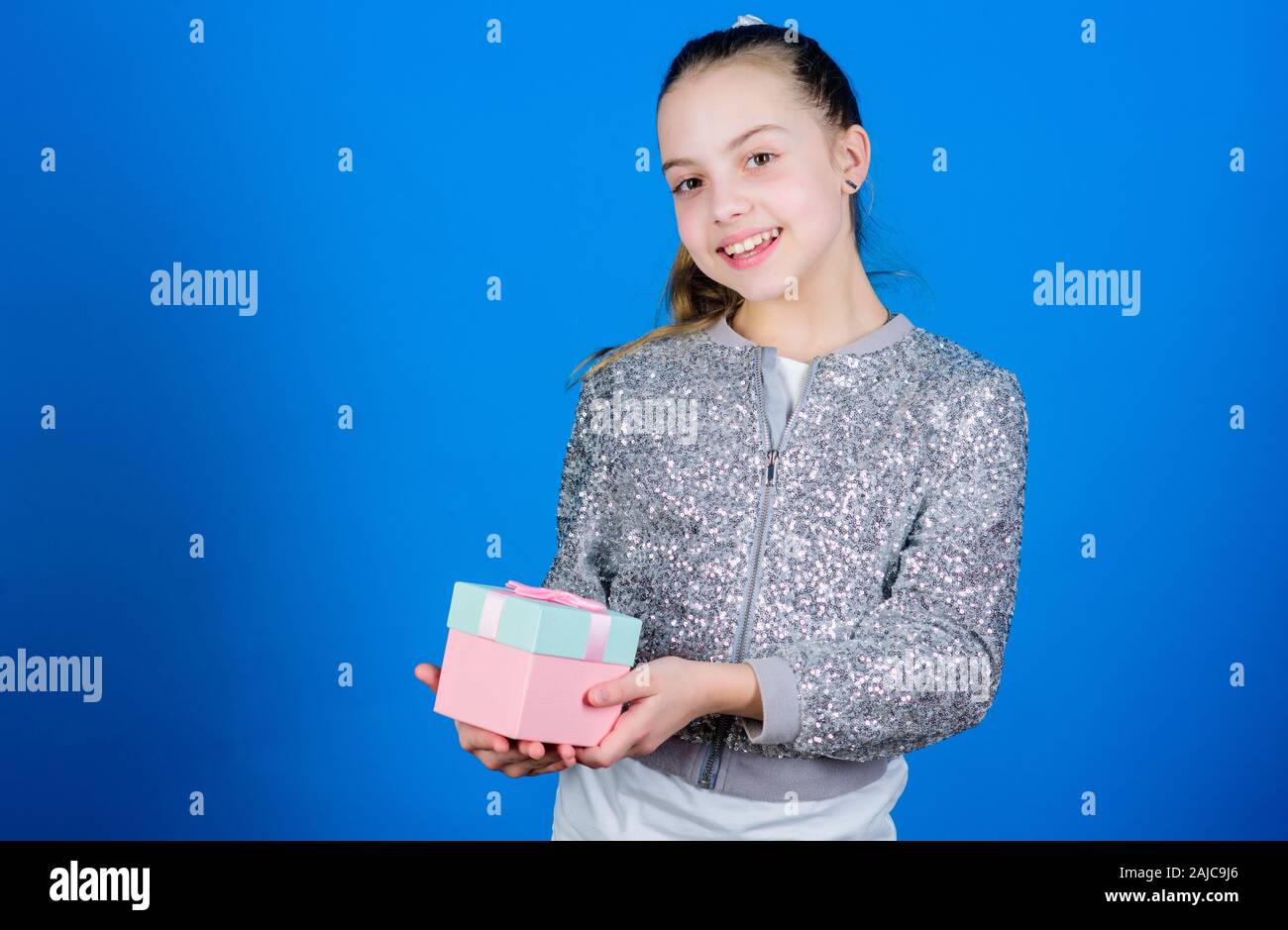 Girl with gift box blue background. Black friday. Shopping day. Cute adorable child carry gift box. Surprise gift box. Birthday wish list. World of happiness. Special happens every day. My precious. Stock Photo