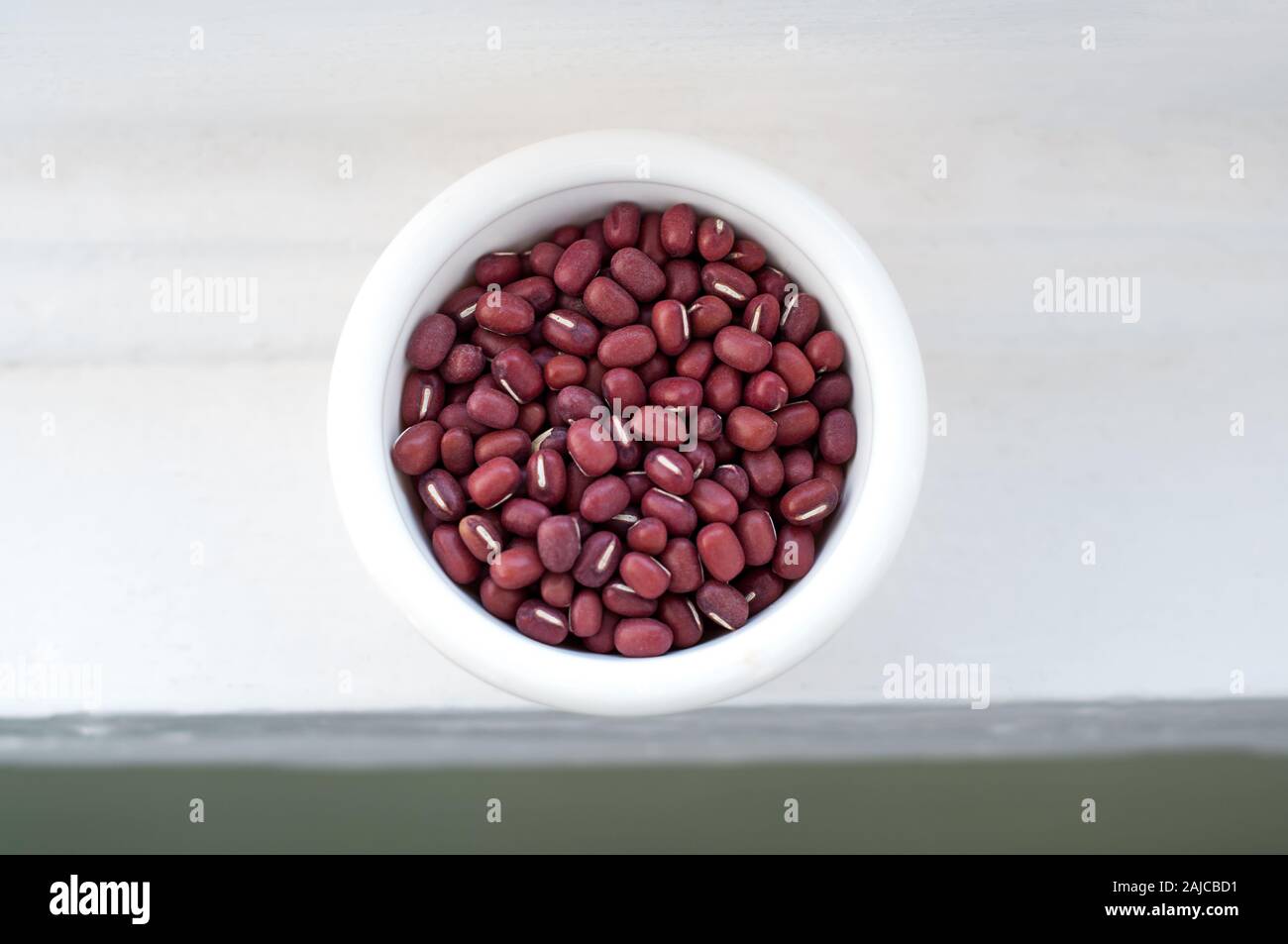 Uncooked Adzuki beans, also called azuki or aduki beans in a white bowl.  These legumes are healthy vegan or vegetarian food. Stock Photo