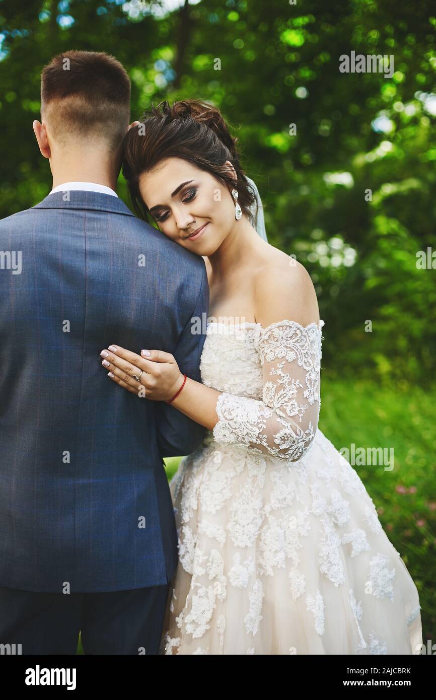 Beautiful plus size model woman with stylish wedding hairstyle in a  fashionable dress hugging handsome groom. Beautiful lady in wedding outfit  posing Stock Photo - Alamy