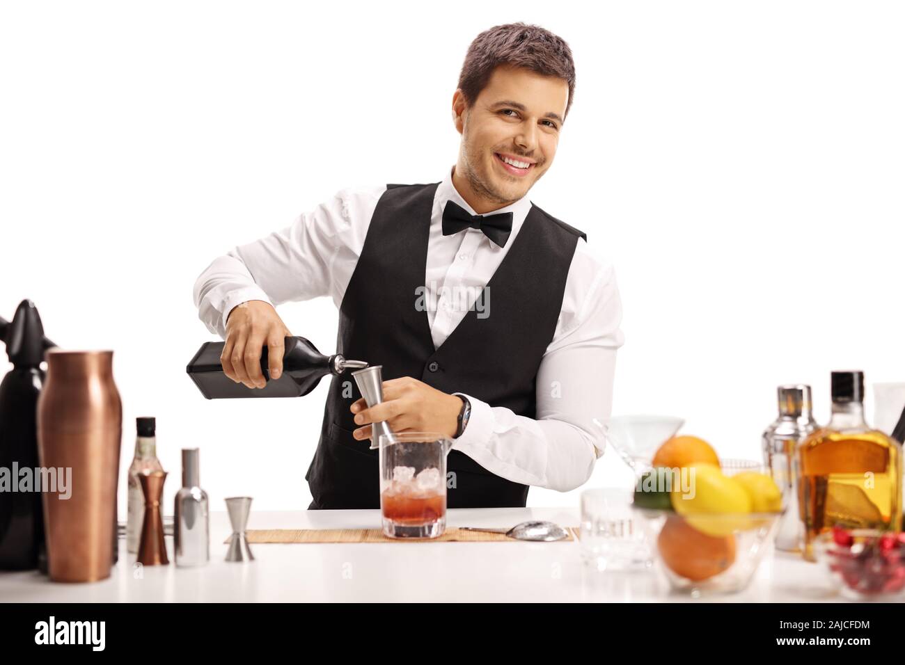 Young barman pouring a drink isolated on white background Stock Photo