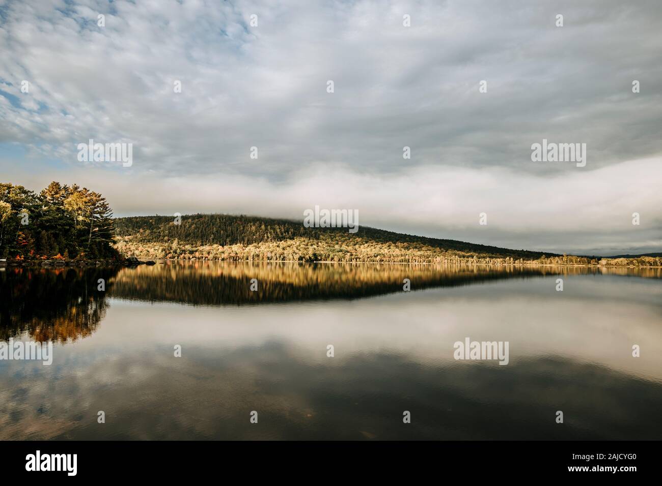 mountain and clouds reflected in calm lake, sunrise Millinocket, Maine Stock Photo