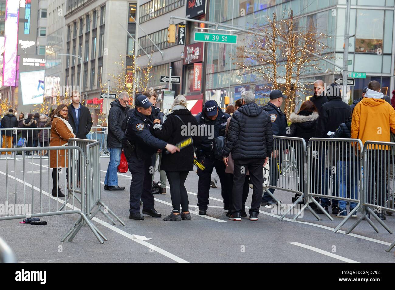 NYPD Counterterrorism police at a Times Square New Years Eve checkpoint check people with handheld metal detectors (New York, December 31, 2019) Stock Photo