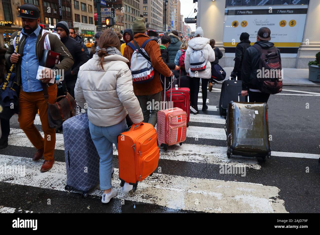 Tourists with rolling suitcases and luggage on a crowded street in