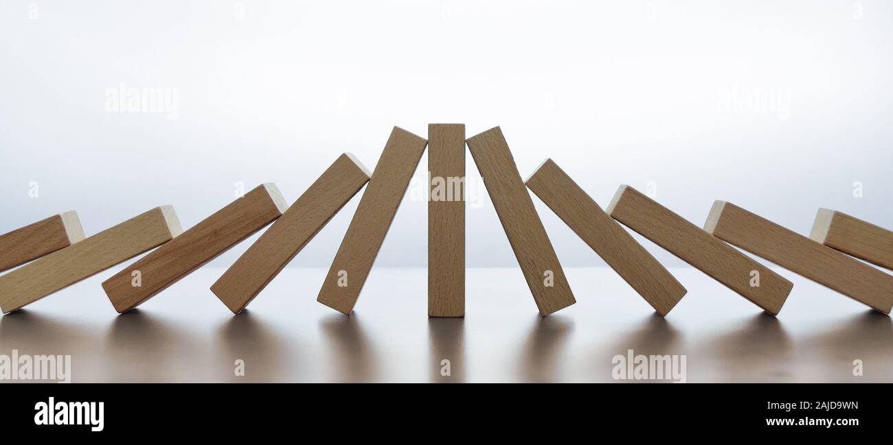 Standing tile (lucky survivor or beneficiary) in-between collision of two domino effects Stock Photo