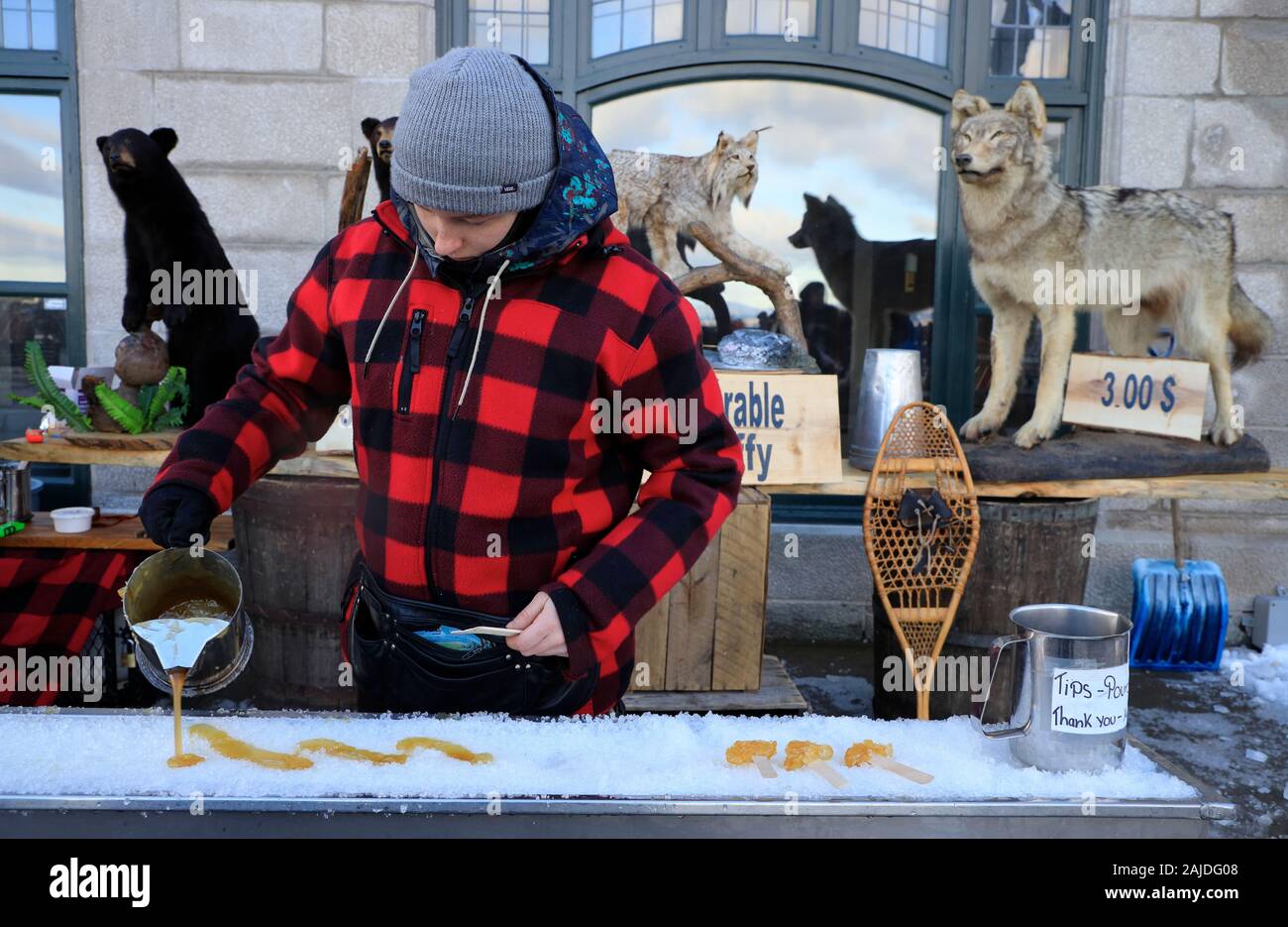 Locals making maple syrup taffy candy on ice for sale on the street of