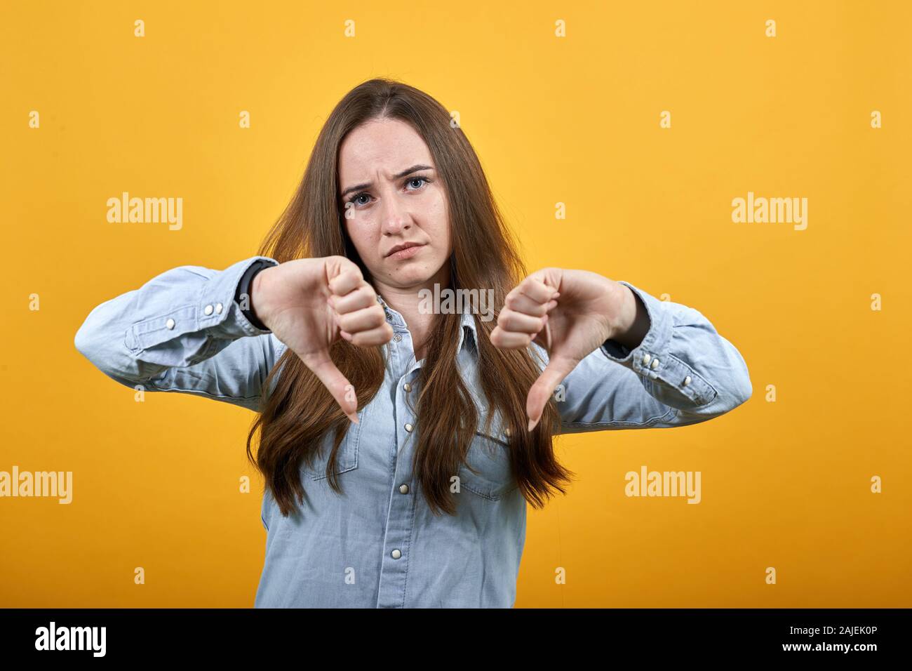 Dissatisfaction caucasian lady keeping thumbs down, disappointed.. Stock Photo