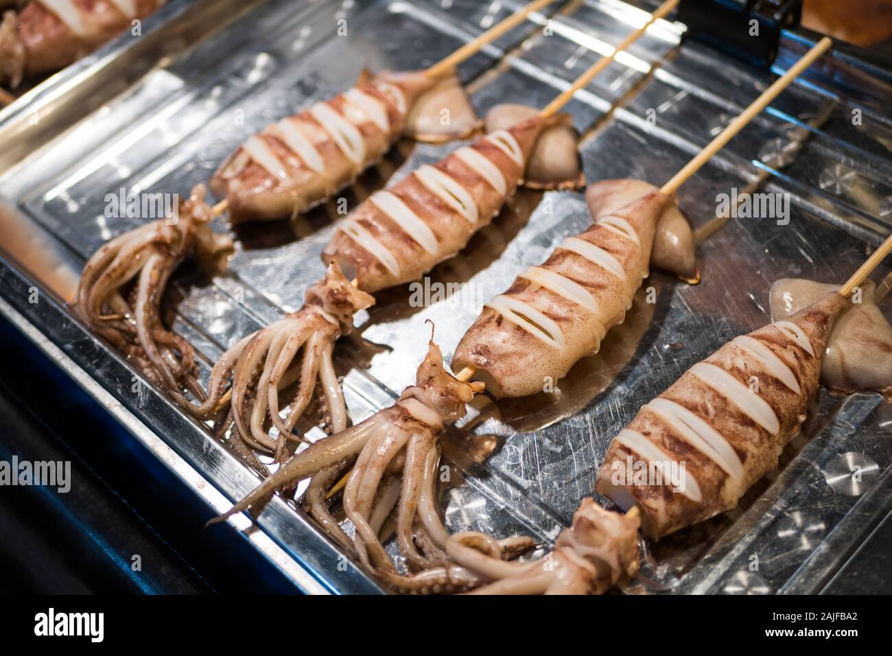 Grilled squids selling at the food stall at the night market in Bangkok