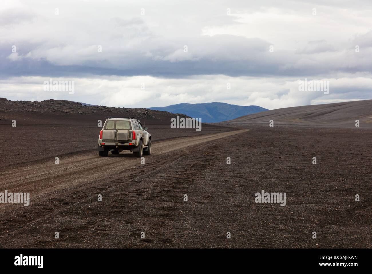 SUV on dirt road against cloudy sky Stock Photo