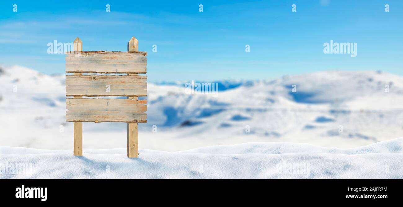 Blank wooden road sign on the snowy mountain. Mockup for adding roadmap text. Stock Photo