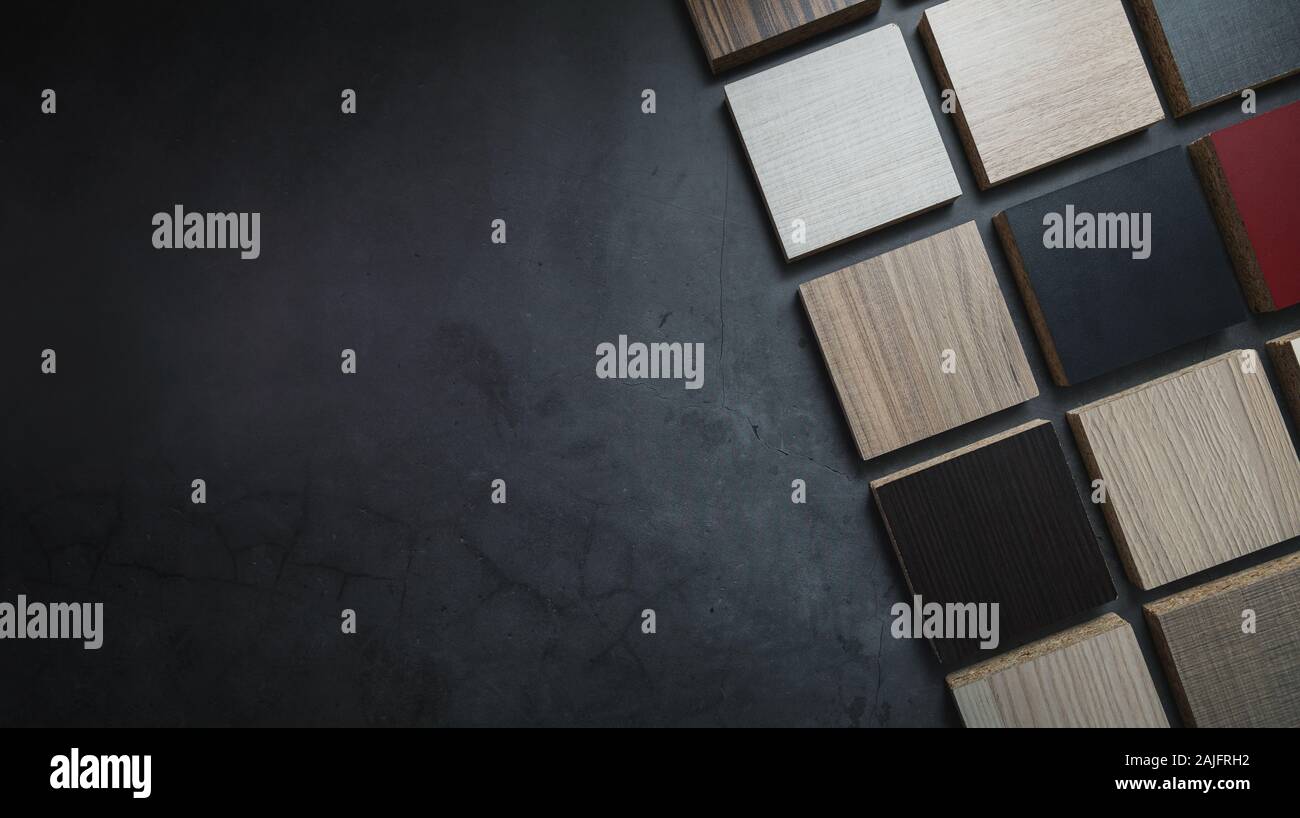 wood texture particle board laminate material samples on dark stone background with copy space Stock Photo