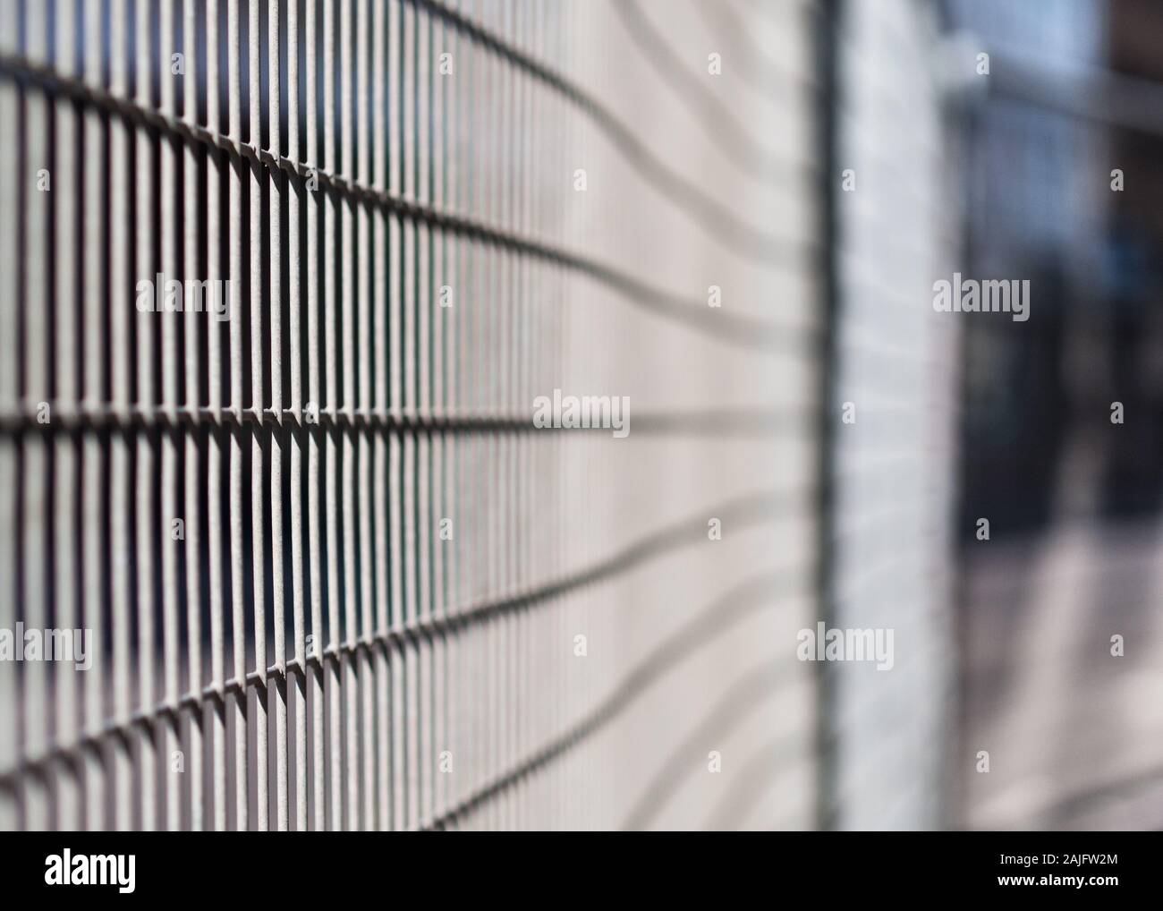 A roadworks fence in London hit by light and creating a geometric pattern Stock Photo