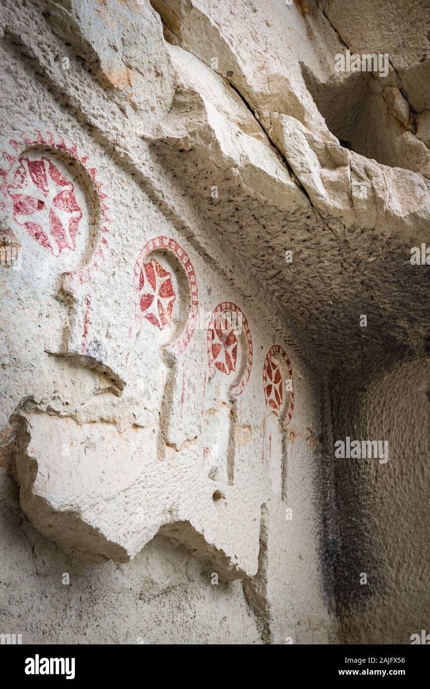 A row of red Maltese crosses decorates the wall of an early Christian church in Goreme Open Air Museum (UNESCO heritage site), Cappadocia, Turkey Stock Photo