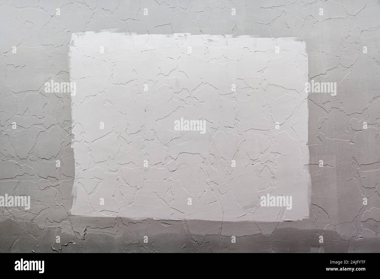 Gray plaster wall background with white rectangle in center, Mockup and backdrop. Stock Photo