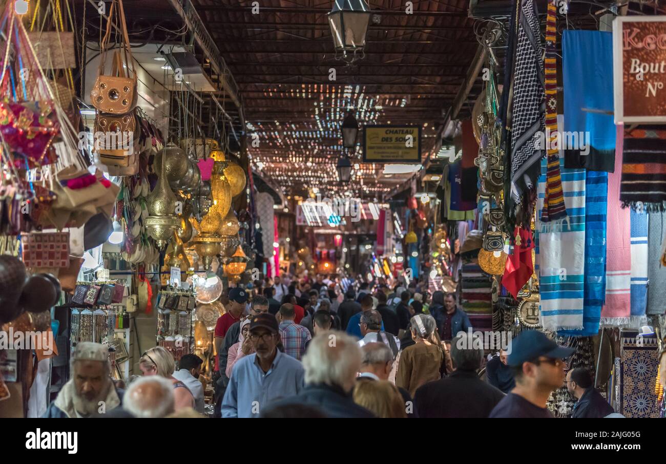 Marrakech, Morocco: People and tourists strolling, booths and stalls in alley nearby Jemma Dar Fna, souk market in Marrakesh medina, crowded bazaar Stock Photo