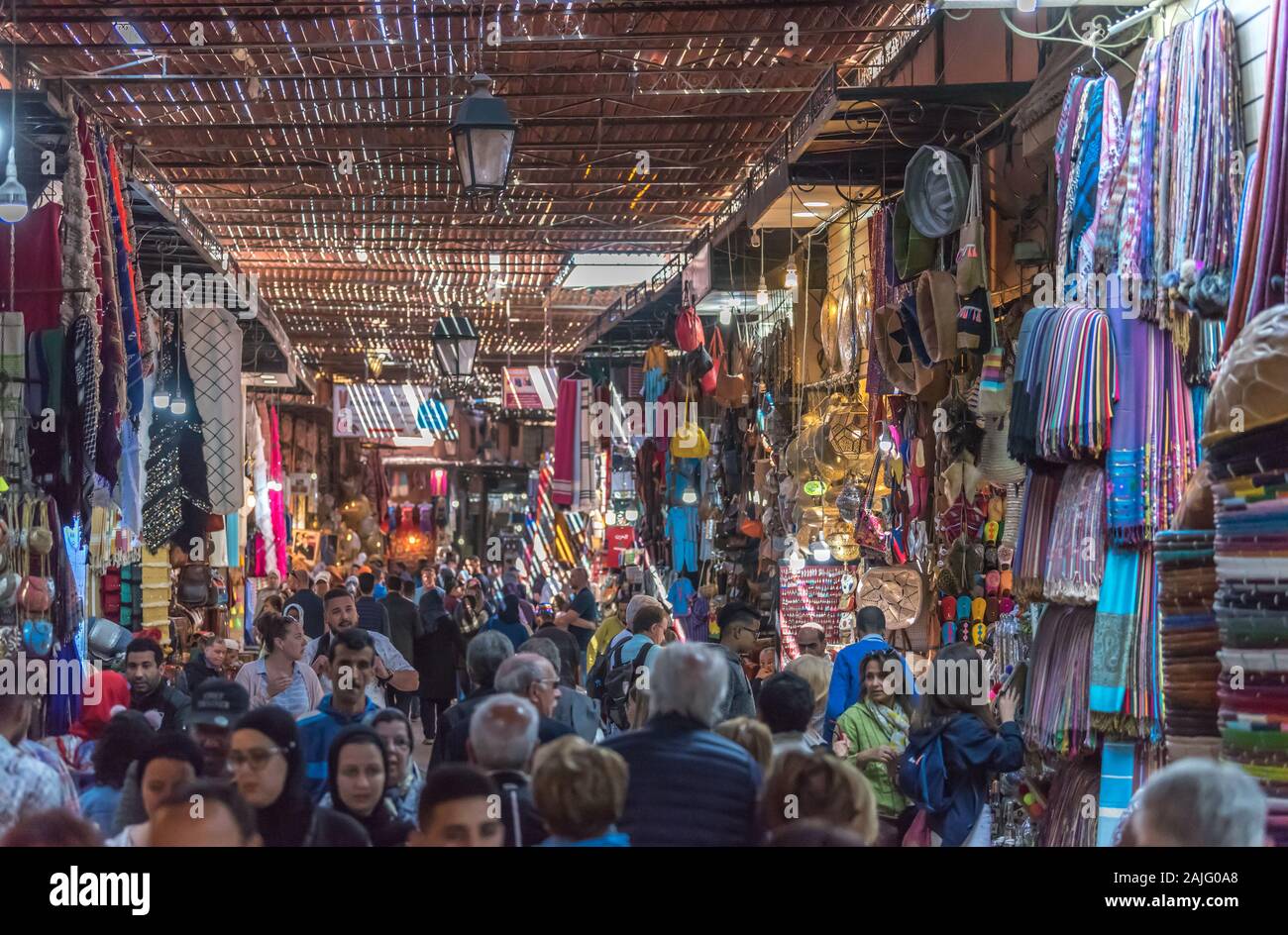 Marrakech, Morocco: People and tourists strolling, booths and stalls in alley nearby Jemma Dar Fna, souk market in Marrakesh medina, crowded bazaar Stock Photo