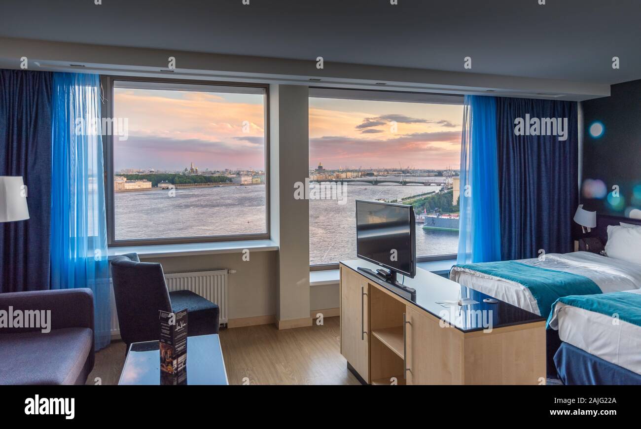 Saint Petersburg, Russia: Luxury modern interiors of hotel suite, floor to ceiling windows, view over Neva river and Saint Petersburg cityscape Stock Photo