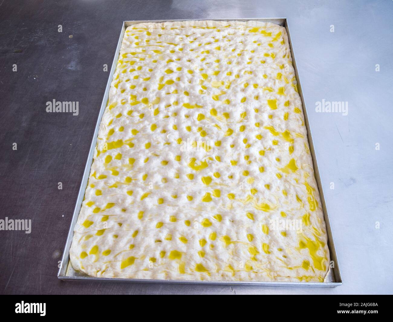 A tray of focaccia Genovese before baking, focaccia is a flat oven-baked Italian bread product, traditional recipe from Liguria region Stock Photo