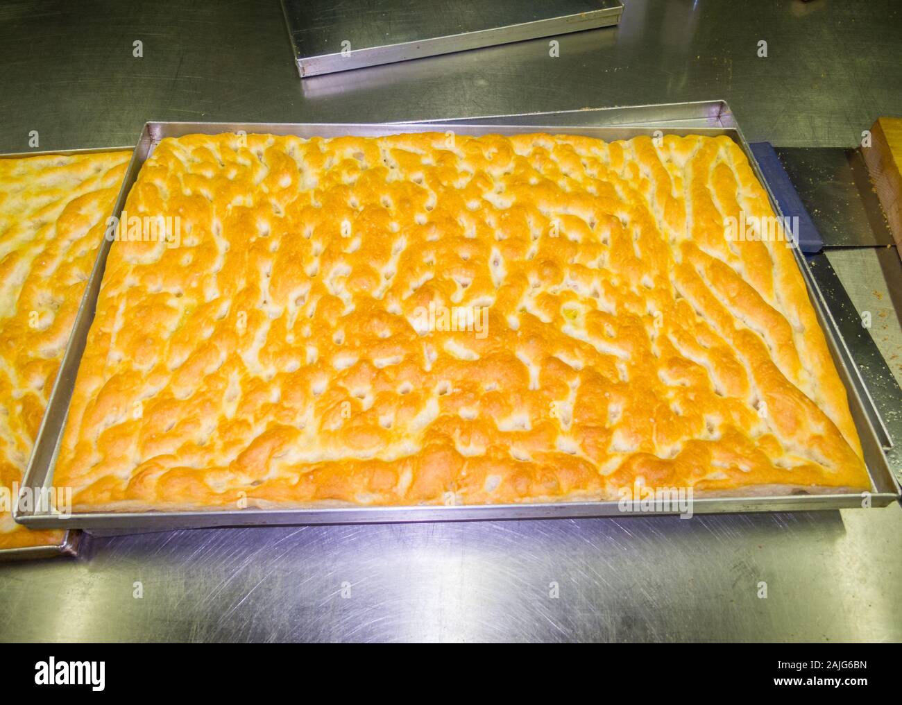 A tray of focaccia Genovese out of the oven, focaccia is a flat oven-baked Italian bread product, traditional recipe from Liguria region Stock Photo