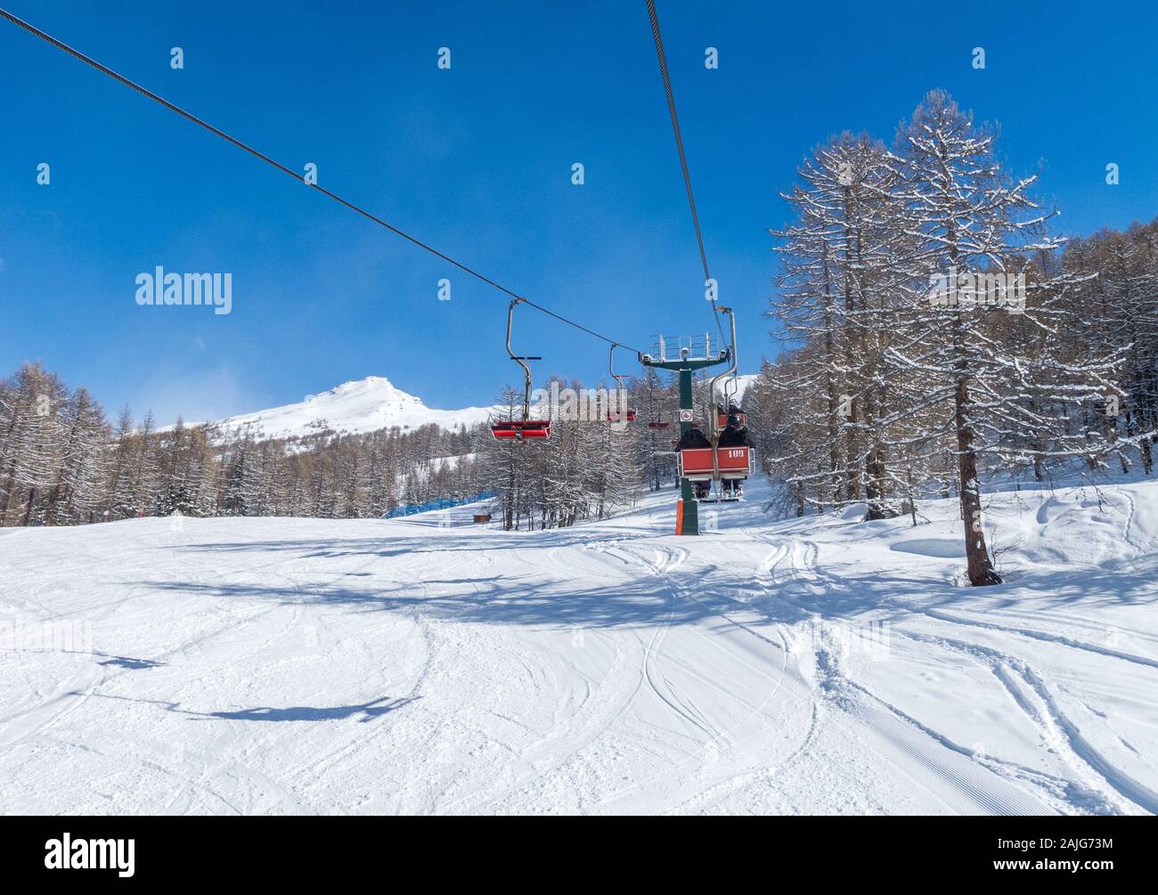 Bardonecchia, Italian Alps, snowy scenery: ski slopes and chairlift (chair lift) with skiers, ski resort and winter snow landscape Stock Photo