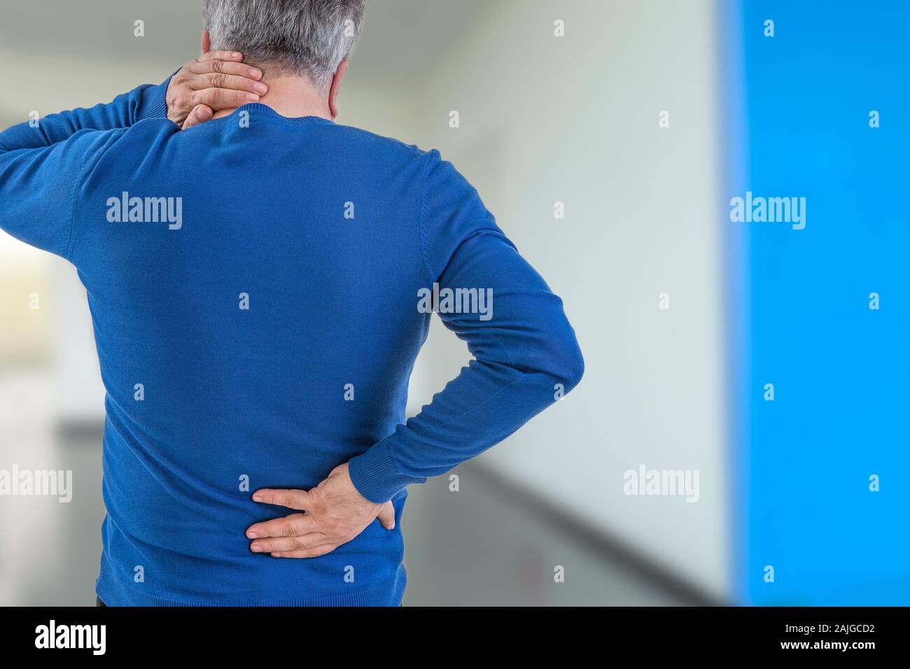 Rear view image of a old man with neck and back injury, on hospital corridor Stock Photo
