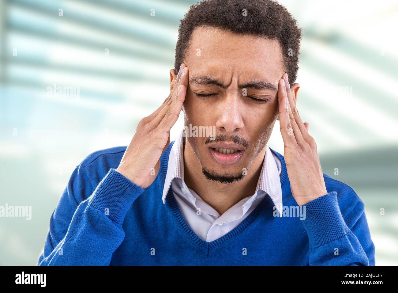 Young man touching temples trying to focus or feeling headache. Stock Photo