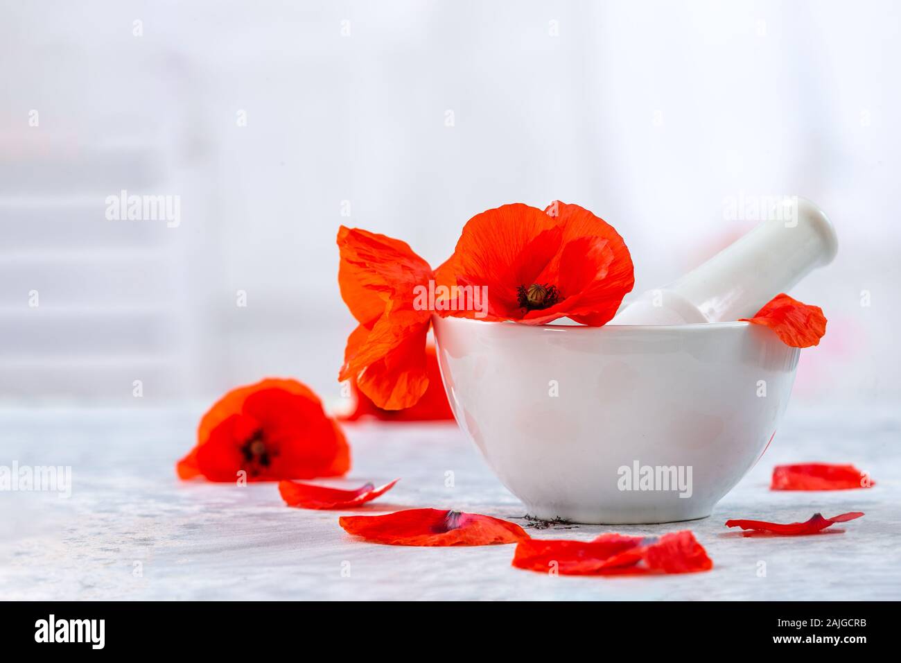 Ceramic, mortar and pestle alternative medicine poppies flowers vintage background Stock Photo