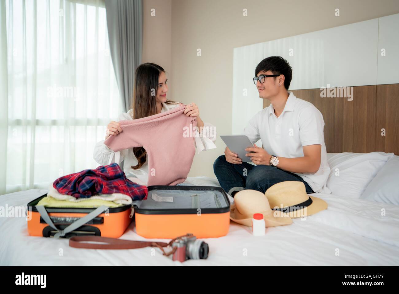 Happiness Asian couple traveler packing suitcases preparing for travel vacation together and looking fun when they preparing to journey. Asian backpac Stock Photo