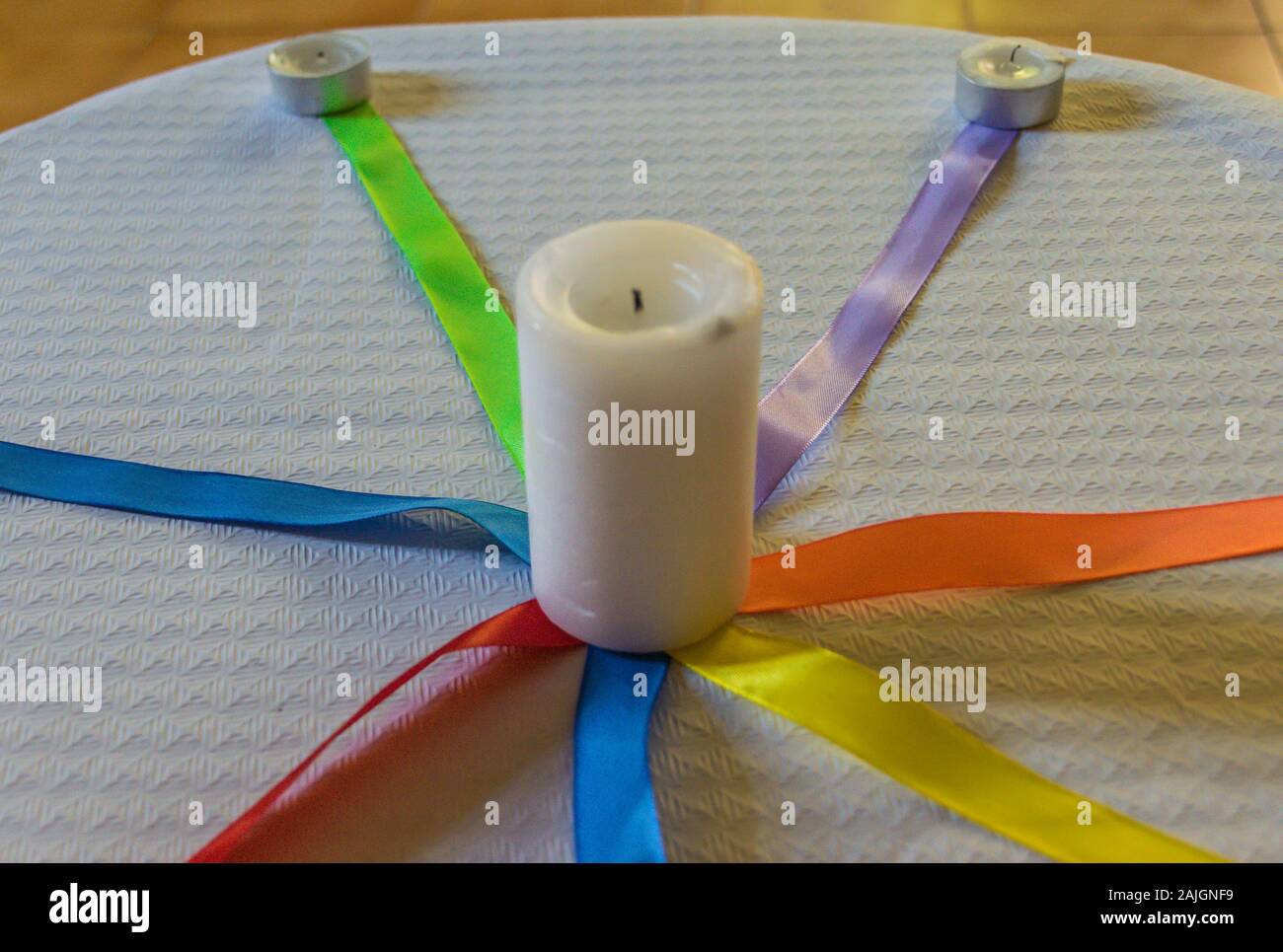 Candles out with colored ties on a table with white paper tablecloth Stock Photo