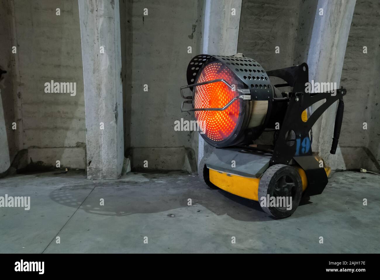 Heavy duty industrial heater blowing hot air in cold building interior