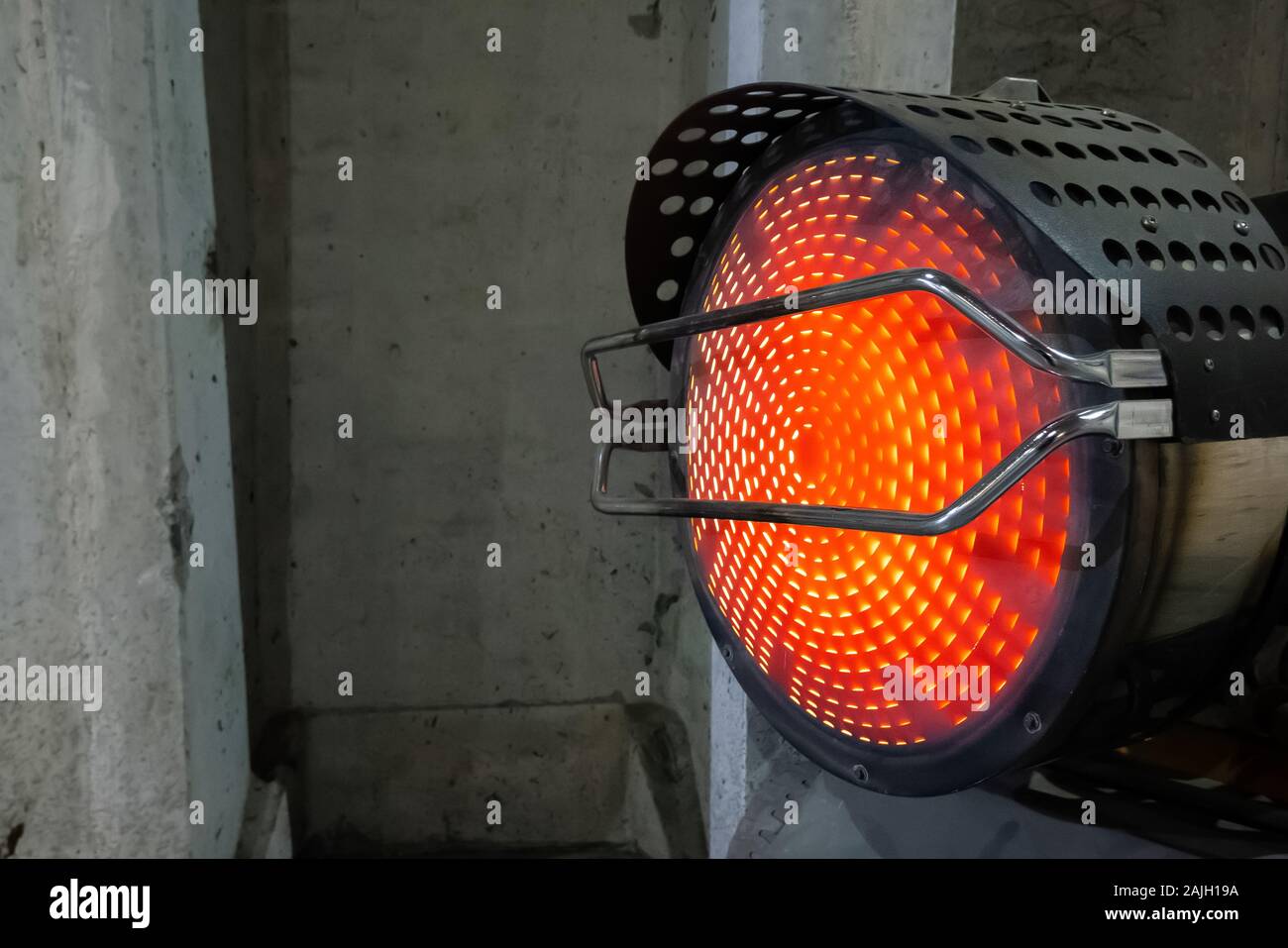 Heavy duty industrial heater blowing hot air in cold building interior