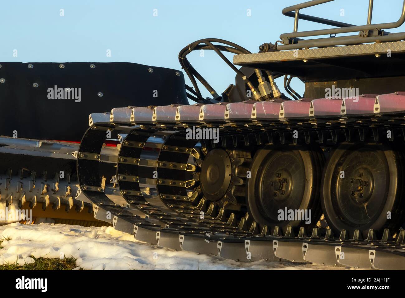Caterpillar spikes on snowmobile in ski resort. Machine wheels with spikes for winter off road, extreme conditions. Tracked quad wheel, all terrain ve Stock Photo