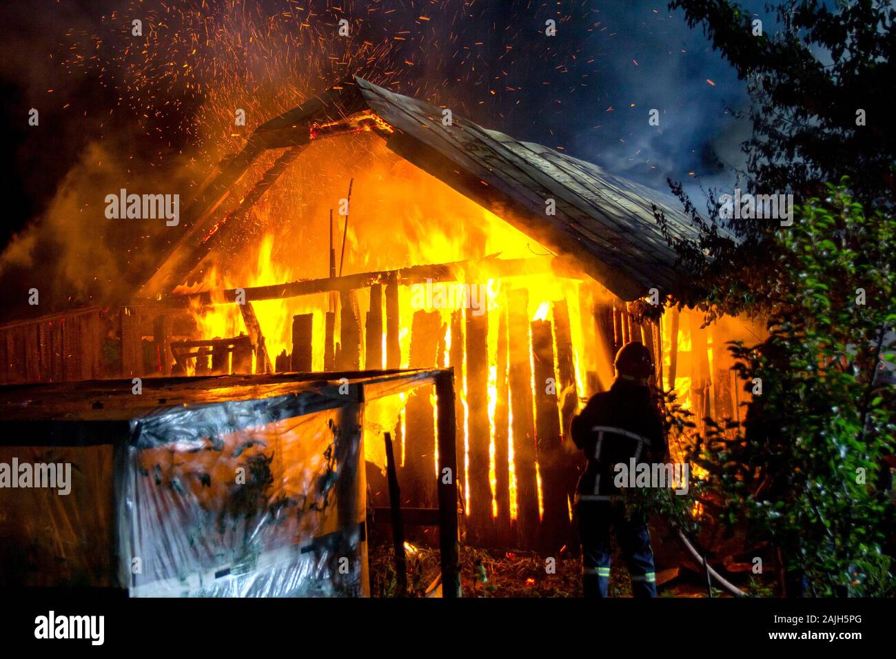 Wooden House Or Barn Burning On Fire At Night Stock Photo