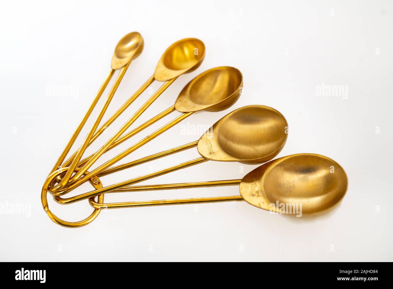 Brass measuring spoons non metric on white background Stock Photo