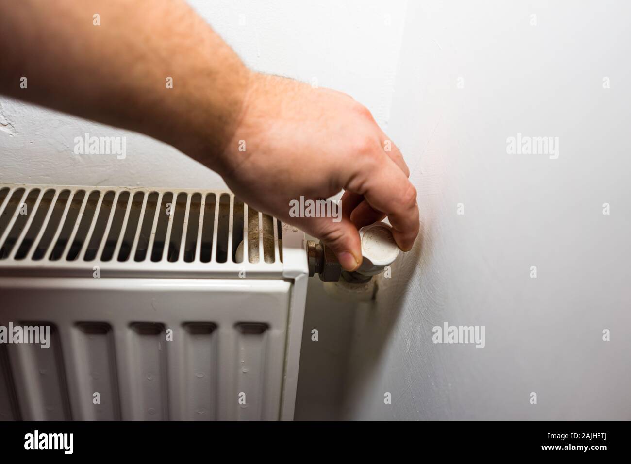 Hand adjusting thermostat valve of heating radiator in a room. Close up  heating radiator. Central heating concept, radiator heater Stock Photo -  Alamy