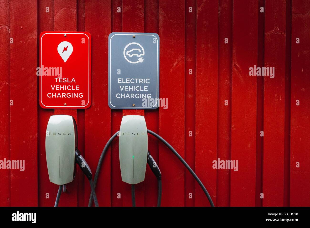 Tesla electric chargers on traditional red wooden house, rorbuer in the