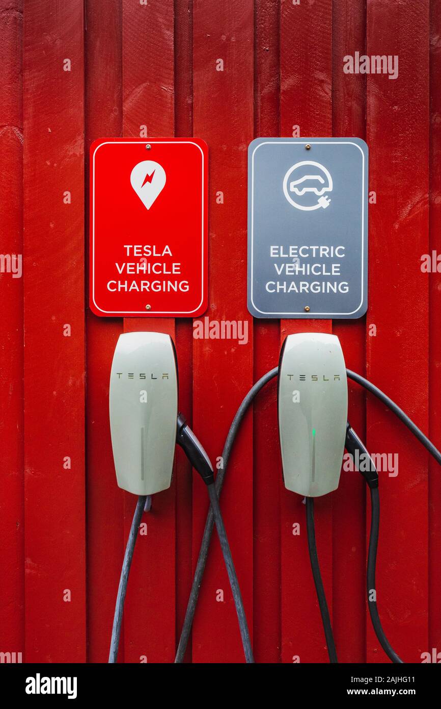 Tesla electric chargers on traditional red wooden house, rorbuer in the