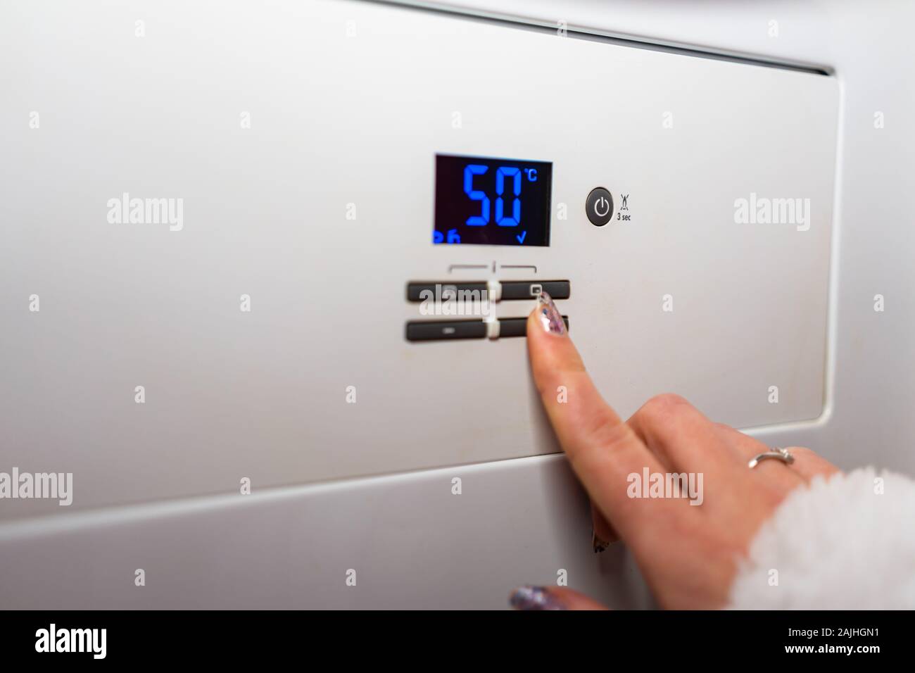 Control panel of central heating. Hand adjusting the room temperature