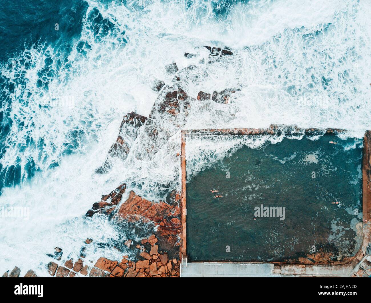 Aerial of a Rockpool with waves crashing over Stock Photo