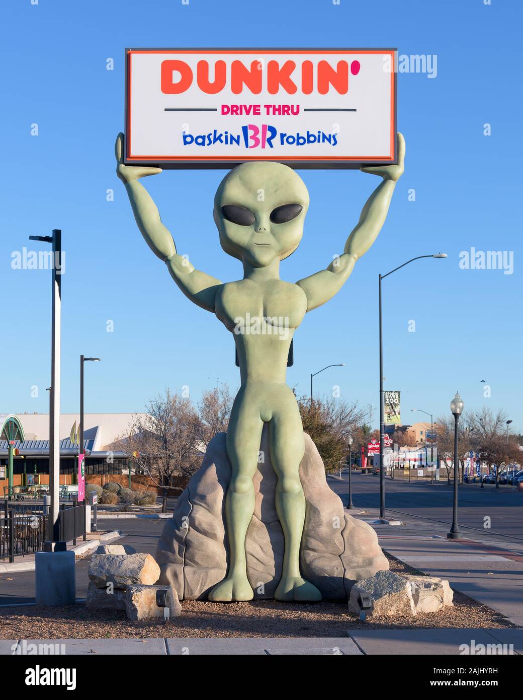 Alien holding up sign at Dunkin Donuts on Main Street in downtown Roswell, New Mexico Stock Photo